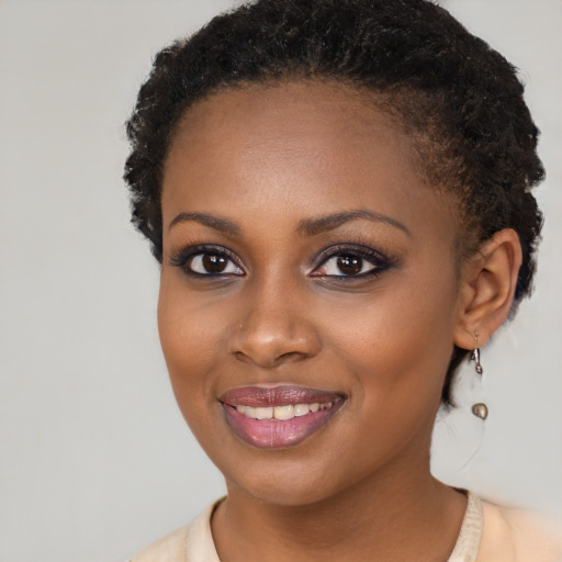 Joyful black young-adult female with short  brown hair and brown eyes