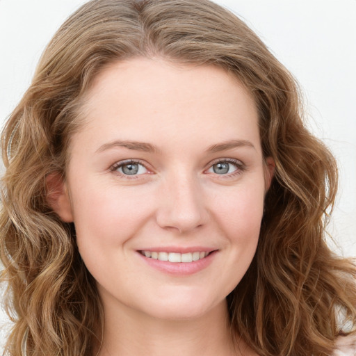 Joyful white young-adult female with long  brown hair and blue eyes