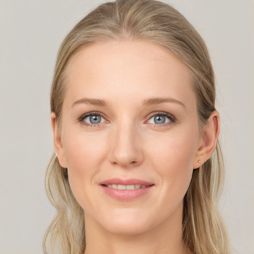 Joyful white young-adult female with long  brown hair and blue eyes