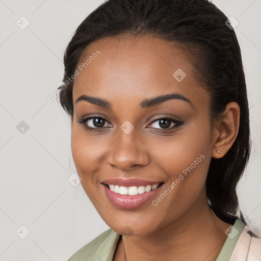 Joyful black young-adult female with long  brown hair and brown eyes