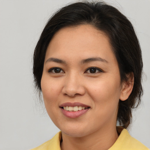 Joyful asian young-adult female with medium  brown hair and brown eyes