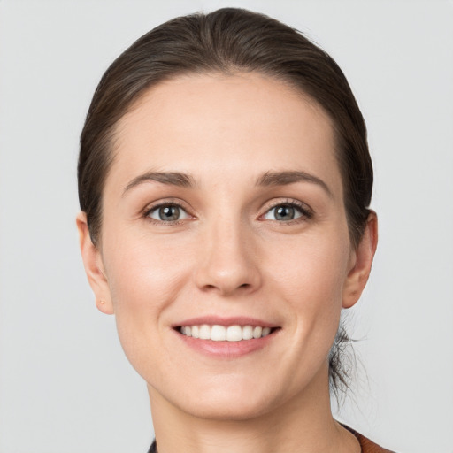 Joyful white young-adult female with short  brown hair and grey eyes