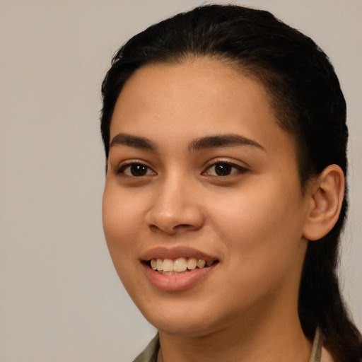 Joyful latino young-adult female with long  black hair and brown eyes