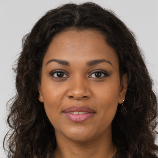 Joyful black young-adult female with long  brown hair and brown eyes
