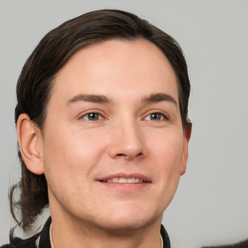 Joyful white young-adult male with short  brown hair and grey eyes