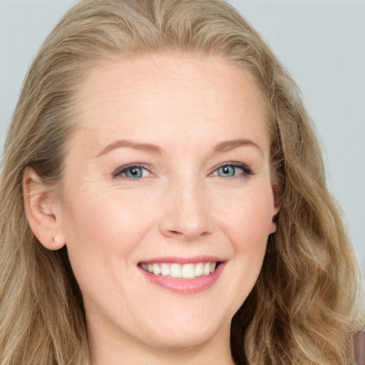 Joyful white young-adult female with long  brown hair and blue eyes