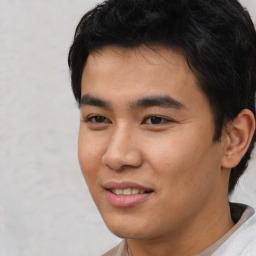 Joyful asian young-adult male with short  black hair and brown eyes