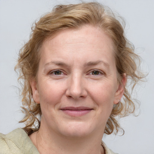 Joyful white adult female with medium  brown hair and blue eyes