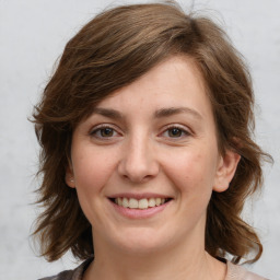 Joyful white young-adult female with medium  brown hair and grey eyes