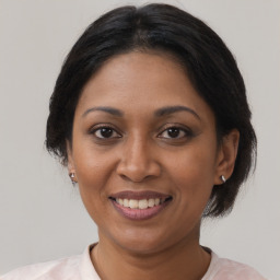 Joyful black adult female with medium  brown hair and brown eyes