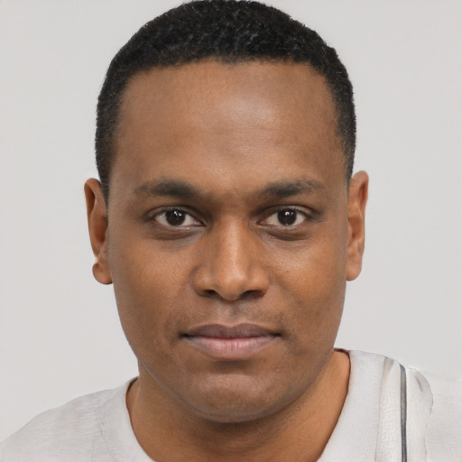 Joyful black young-adult male with short  brown hair and brown eyes