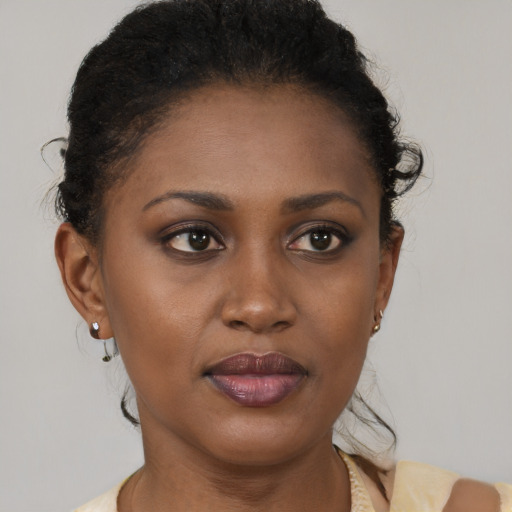 Joyful black young-adult female with short  brown hair and brown eyes