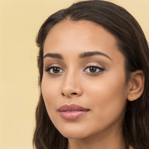 Joyful latino young-adult female with long  brown hair and brown eyes