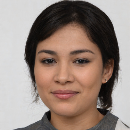Joyful latino young-adult female with medium  black hair and brown eyes