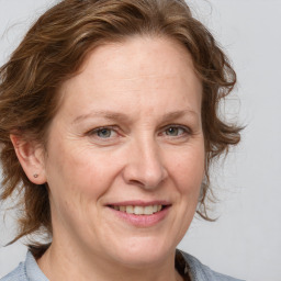 Joyful white adult female with medium  brown hair and grey eyes