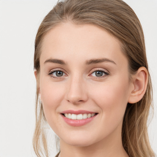 Joyful white young-adult female with long  brown hair and blue eyes