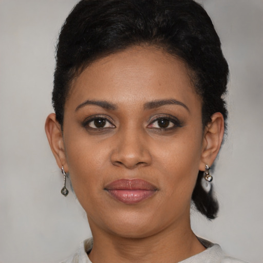 Joyful black young-adult female with short  brown hair and brown eyes