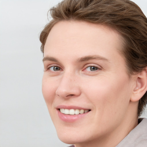 Joyful white young-adult female with short  brown hair and blue eyes