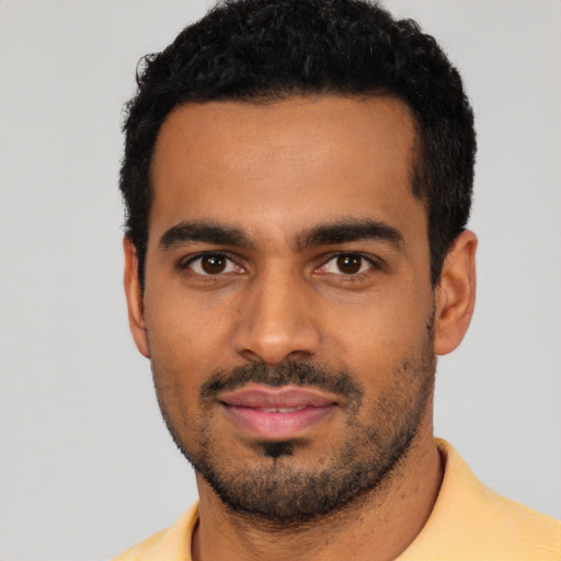 Joyful latino young-adult male with short  black hair and brown eyes