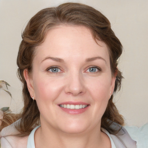 Joyful white young-adult female with medium  brown hair and blue eyes