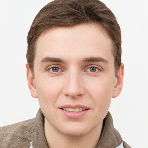 Joyful white young-adult male with short  brown hair and grey eyes