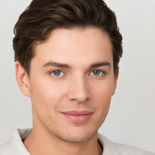 Joyful white young-adult male with short  brown hair and grey eyes