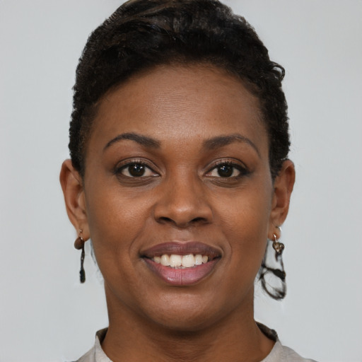 Joyful black young-adult female with short  brown hair and brown eyes