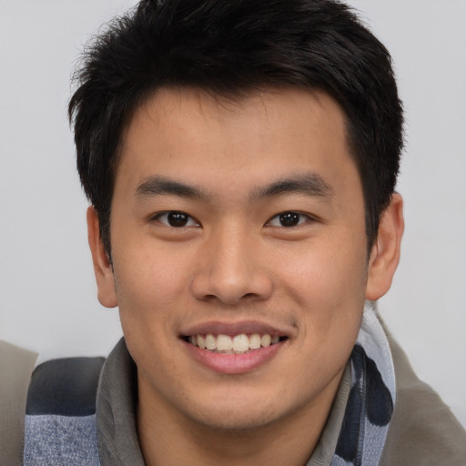 Joyful asian young-adult male with short  brown hair and brown eyes
