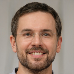 Joyful white adult male with short  brown hair and brown eyes