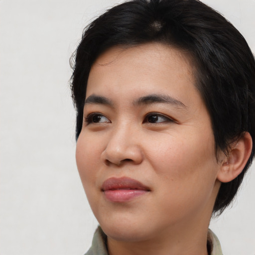 Joyful asian young-adult female with short  brown hair and brown eyes