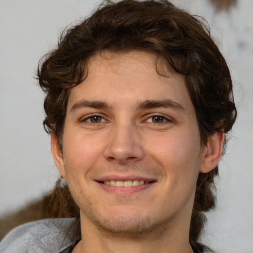 Joyful white young-adult male with medium  brown hair and brown eyes