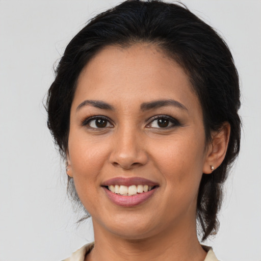 Joyful latino young-adult female with medium  brown hair and brown eyes