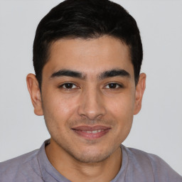 Joyful latino young-adult male with short  brown hair and brown eyes