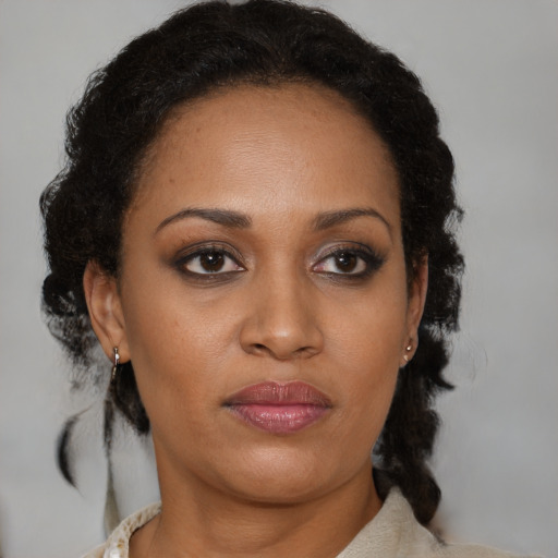 Joyful black young-adult female with medium  brown hair and brown eyes