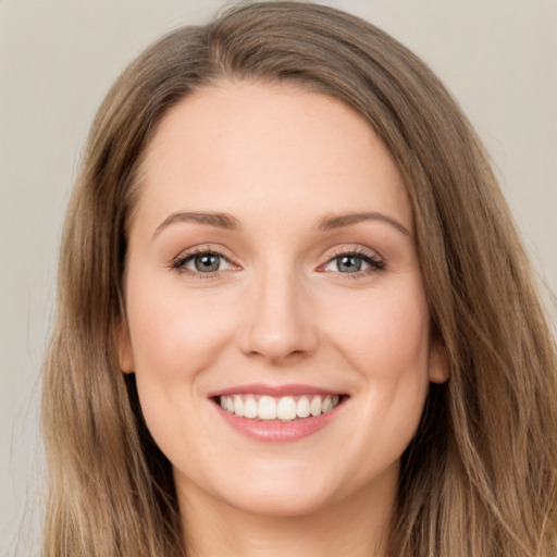 Joyful white young-adult female with long  brown hair and green eyes