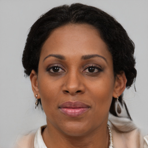 Joyful black adult female with medium  brown hair and brown eyes