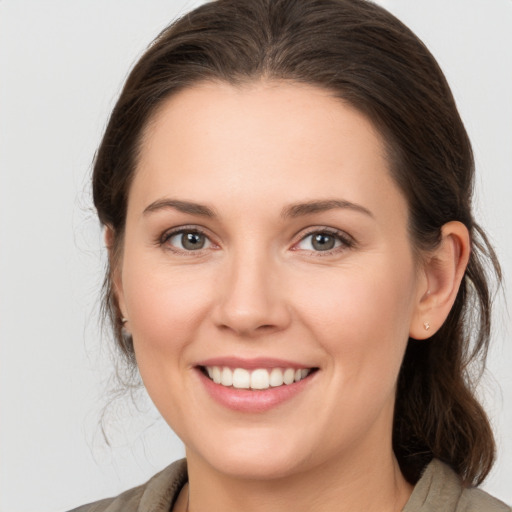 Joyful white young-adult female with medium  brown hair and grey eyes