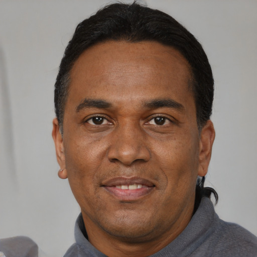 Joyful black adult male with short  black hair and brown eyes