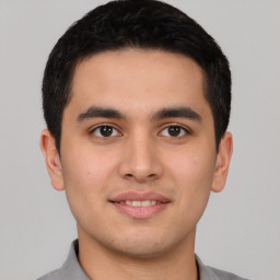 Joyful latino young-adult male with short  brown hair and brown eyes