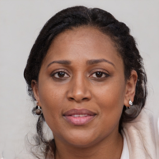 Joyful black adult female with medium  brown hair and brown eyes