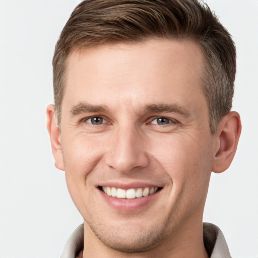 Joyful white young-adult male with short  brown hair and grey eyes