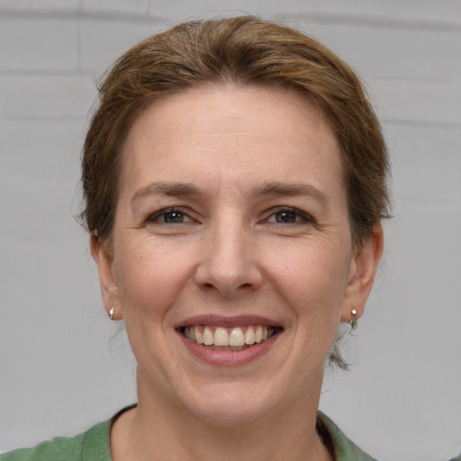 Joyful white adult female with short  brown hair and grey eyes