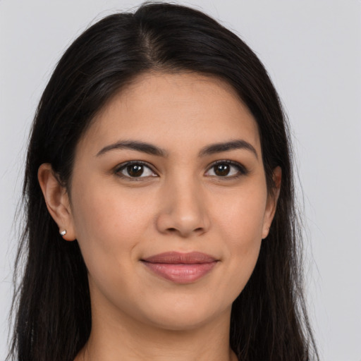 Joyful latino young-adult female with long  brown hair and brown eyes