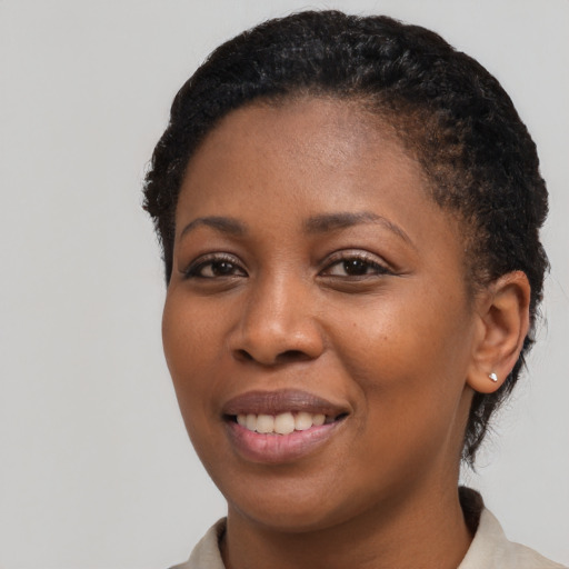Joyful black young-adult female with short  black hair and brown eyes