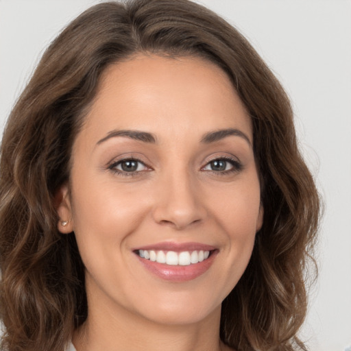 Joyful white young-adult female with long  brown hair and brown eyes