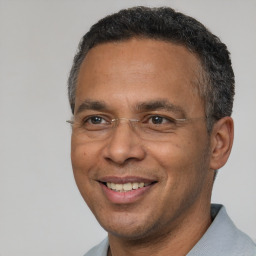 Joyful black adult male with short  black hair and brown eyes