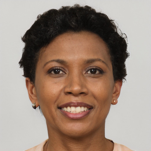 Joyful black adult female with short  brown hair and brown eyes