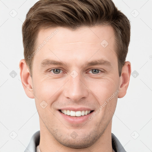 Joyful white young-adult male with short  brown hair and grey eyes