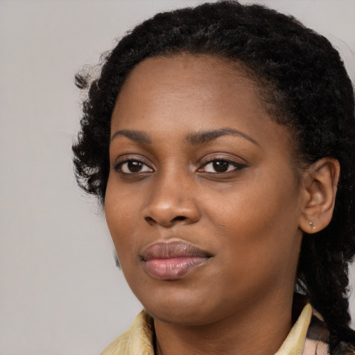 Joyful black young-adult female with long  black hair and brown eyes