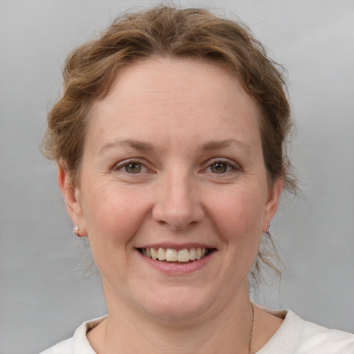 Joyful white adult female with medium  brown hair and blue eyes